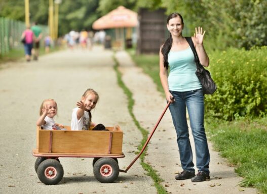Kvinde der trækker 2 børn i en trækvogn